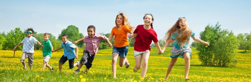 Børn løber, griner og spilder havespil udenfor om sommeren