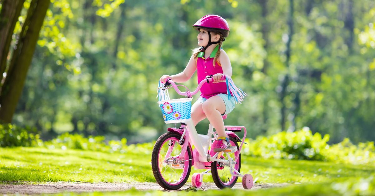 Pige kører på børnecykel